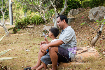father playing bubble soap with his son in the park