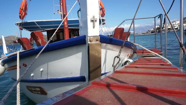 Small ship in the harbor, view of Crete, sea. Camera is on the ship deck.