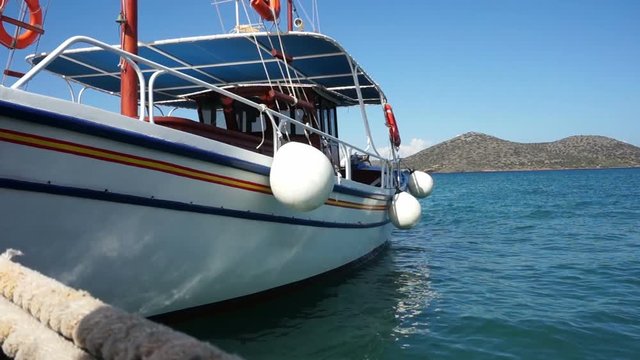 Small ship in the harbor, view of Crete, sea.