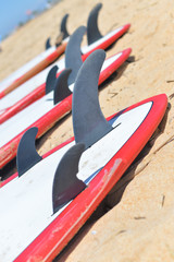 Group of surfboards lying on sand ocean beach background