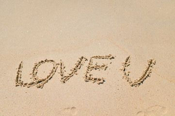 Top view of romantic sign hand drawing on the sandy beach
