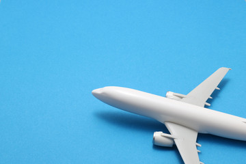 Miniature of toy airplane on blue background.