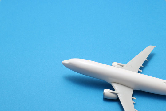 Miniature of toy airplane on blue background.