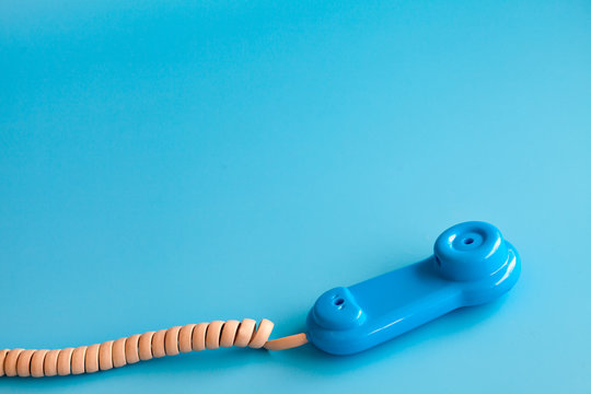 Colorful plastic toy mobile phone on a blue background