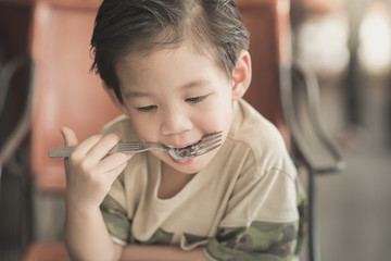 Cute Asian chid eating Spaghetti Carbonara