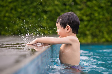 Asian child playing in swimming pool