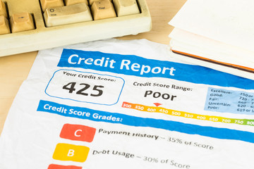 Poor credit score report on wrinkled paper with pen and keyboard