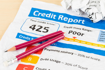 Poor credit score report on wrinkled paper with pen and calculat