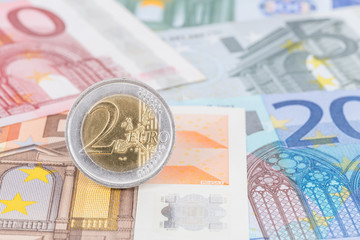 Two euro coin stand on banknote money
