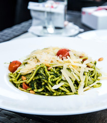 Pasta with pesto sauce and nuts on a the table
