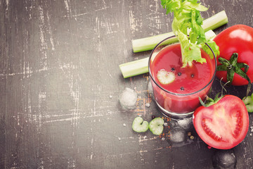 Tomato juice in glass, tomatoes and celery, top view, copy space, tinted