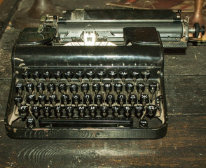 Vintage black typewriter on an old wooden table