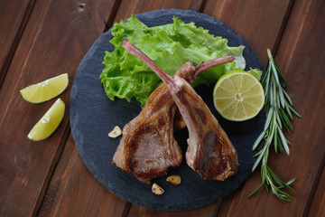 Above view of a stone slate tray with grilled lamb chops