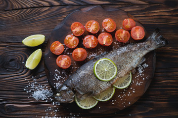 Whole baked trout with cherry tomatoes, above view
