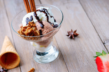 Ice cream sundae, waffle cone, walnuts and sliced strawberry 