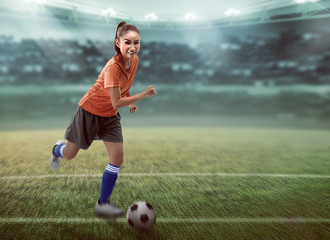 Female football player dribbling ball