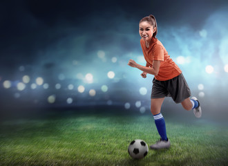 Obraz na płótnie Canvas Female football player dribbling ball