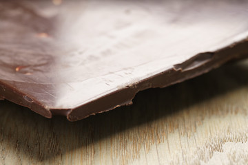 whole homemade bar of chocolate with cashew nuts, on wooden board shalow focus