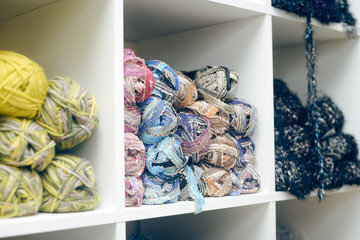 Colorful balls of wool piled up on shelf