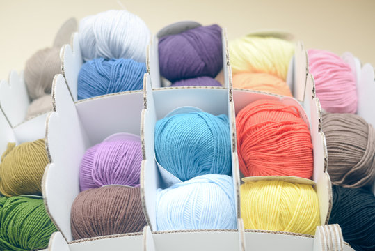 Colorful balls of wool or cotton yarn piled up on shop shelf