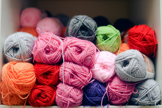 Closeup on colorful balls of wool or cotton yarn piled up on shop shelf