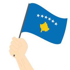 Hand holding and raising the national flag of Kosovo