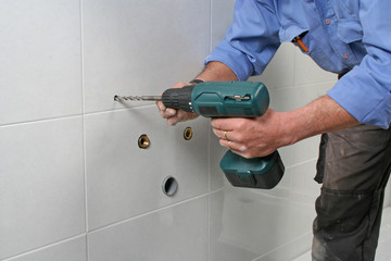 Construction worker drilling holes installing a sink
