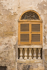 Fototapeta na wymiar Yellow window with an arch and shutter, island Malta