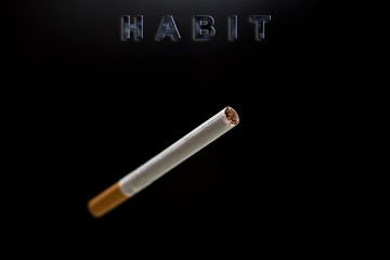 cigarette, text habit on black background