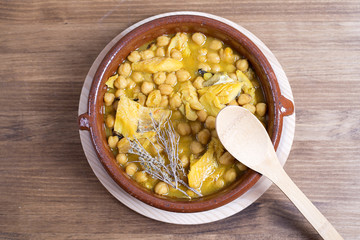 View on chickpeas cereals with greenery and utensils on wooden table