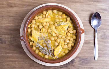 View on chickpeas cereals with greenery and utensils on wooden table