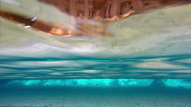 Underwater view of the Trevi fountain (Fonatan di Trevi) in Rome, Italy. People are throwing coins in the pool for good luck