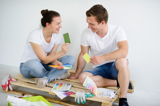 Young couple selects colors for coloring of the room.