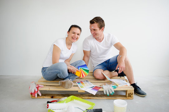 The young couple selects color of a decor in the new apartment.