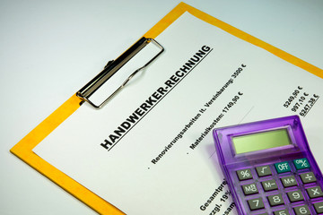 Rechnung eines Handwerkers und ein Taschenrechner