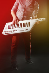 Male hands with synthesizer on dark background