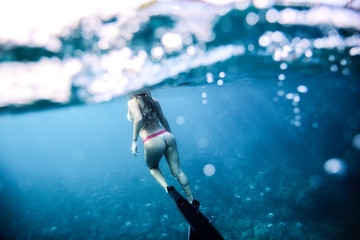 Fototapeta na wymiar Woman with nice booty swims in the ocean