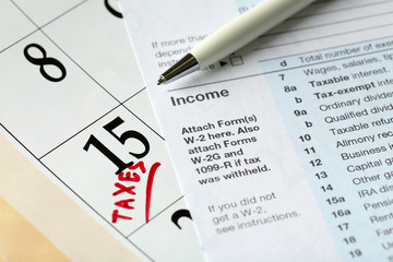 A red tax mark in the calendar, euro coins and tax form, close up