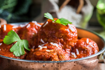 Closeup of meatballs in tomato sauce with parsley and rice