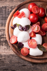 mozzarella balls with tomatoes and basil on slate board