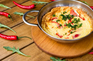 scrambled eggs in a frying pan on a wooden background