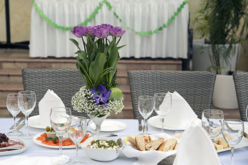 Beautifully decorated table in the restaurant. Fresh flowers and fruit.