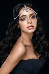 Beautiful woman portrait on black background with crown on head. 