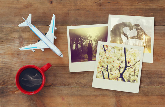 travel instant photographs next to cup of coffee and airplane