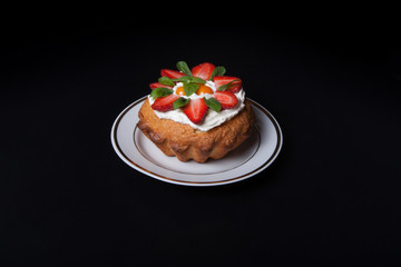 Fresh cake with cream and berries on black background