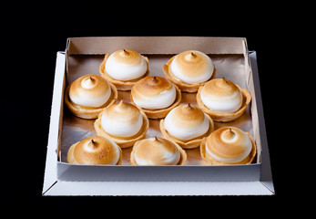 Tartlets with white cream and lemon curd on a dark background