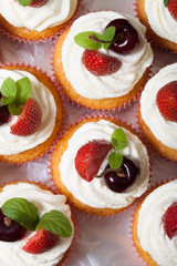 Fresh cupcakes with cream and berries