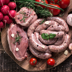 Fresh butcher cut meat assortment garnished with fresh rosemary on wooden table