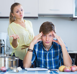 Upset man and  housewife having bad argument indoors