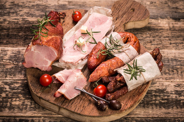 Antipasto catering platter with salami and meat on a wooden background